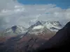 Paysages alpins de Savoie - Montagnes aux cimes enneigées et nuages dans le ciel