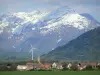 Paysages du Dauphiné - Trièves : village, éolienne, pâturages, forêt et montagnes aux cimes enneigées