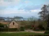 Paysages du littoral de Bretagne - Petite maison en pierre entourée de pelouse et d'arbres, côte et mer (la Manche) au loin