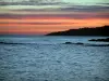 Paysages du littoral de la Côte d'Azur - Ciel rouge avec des nuages gris au lever du soleil, côte, rochers (écueils) et mer méditerranée