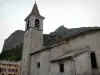 Pedra de ouro - Igreja da aldeia e paredes rochosas no fundo