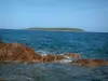 Plage de Palombaggia - Rochers dans la mer méditerranée et une des îles Cerbicale (réserve naturelle) en arrière-plan
