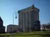 Pons - Lampadaire, pelouse, jet d'eau et donjon de la cité médiévale, en Saintonge