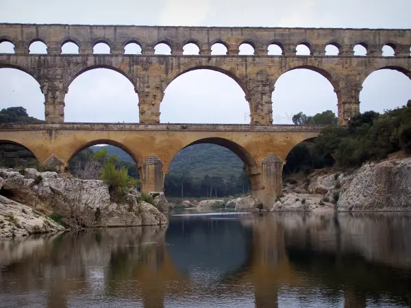 Pont du Gard bridge - Roman aqueduct (ancient monument) with three levels of arcades (arches) spanning the River Gardon; in the town of Vers-Pont-du-Gard