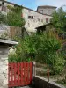 Poudenas - Portillon rouge d'un jardin et façade du château