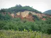 Provençal colorado - Vineyards, grassland, trees with ochre cliffs and Fées chimneys in background (former ochre careers of Rustrel)