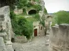 Reiseführer von der Provence-Alpen-Côte d'Azur - Les Baux-de-Provence - Mäuerchen und Treppe aus Stein, Löcher in den Felsen, Bäume und Büsche