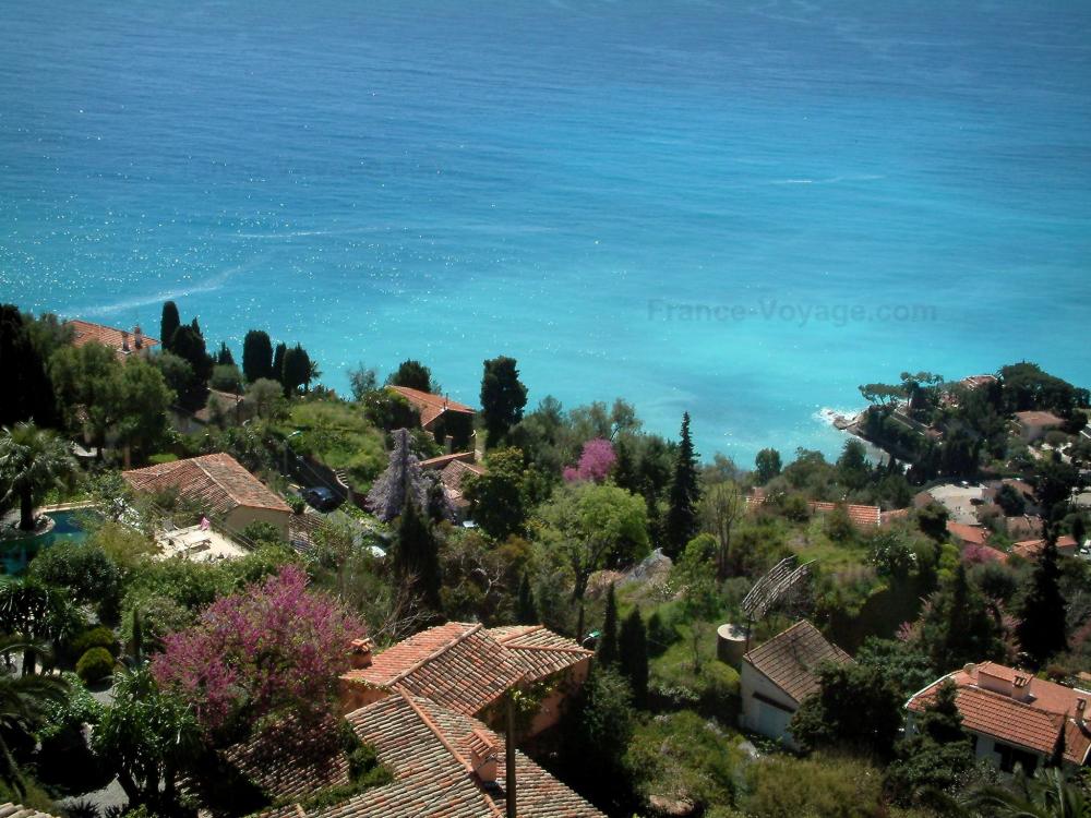 Guide de Provence-Alpes-Côte d'Azur - Paysages du littoral de la Côte d'Azur - Villas entourées de végétation situées en bord de mer, eau turquoise
