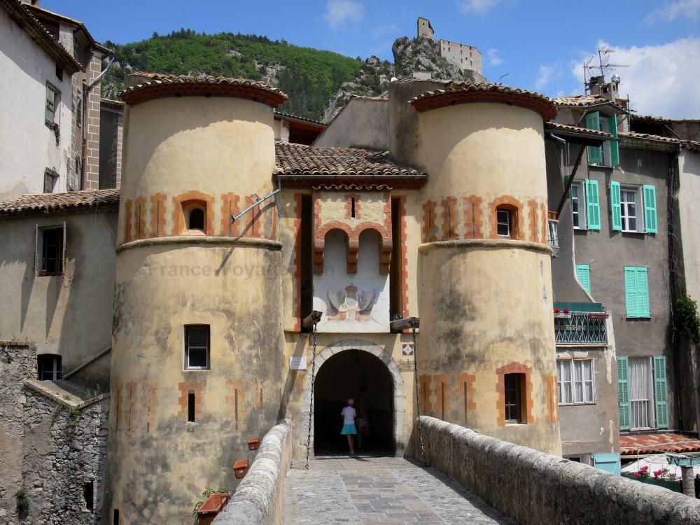 Guide de Provence-Alpes-Côte d'Azur - Entrevaux - Porte Royale et son pont-levis, maisons du village médiéval et citadelle surplombant l'ensemble