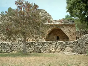 Pueblo de Les Bories - Cabaña (edificio) con un pan seco horno de piedra, paredes y árboles