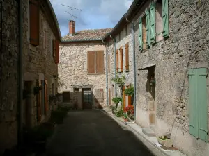Puycelsi - Stone houses with flowerpots and cloudy sky