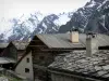 Queyras地区自然公园 - Saint-Véran村：传统房屋，屋顶覆盖着落叶松木瓦和板岩，可以看到山脉和白雪覆盖的山峰