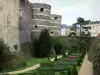 Raivas - Torres do castelo feudal (fortaleza medieval que abriga o museu de tapeçaria), jardim (canteiros de flores, arbustos cortados), árvores e edifícios da cidade