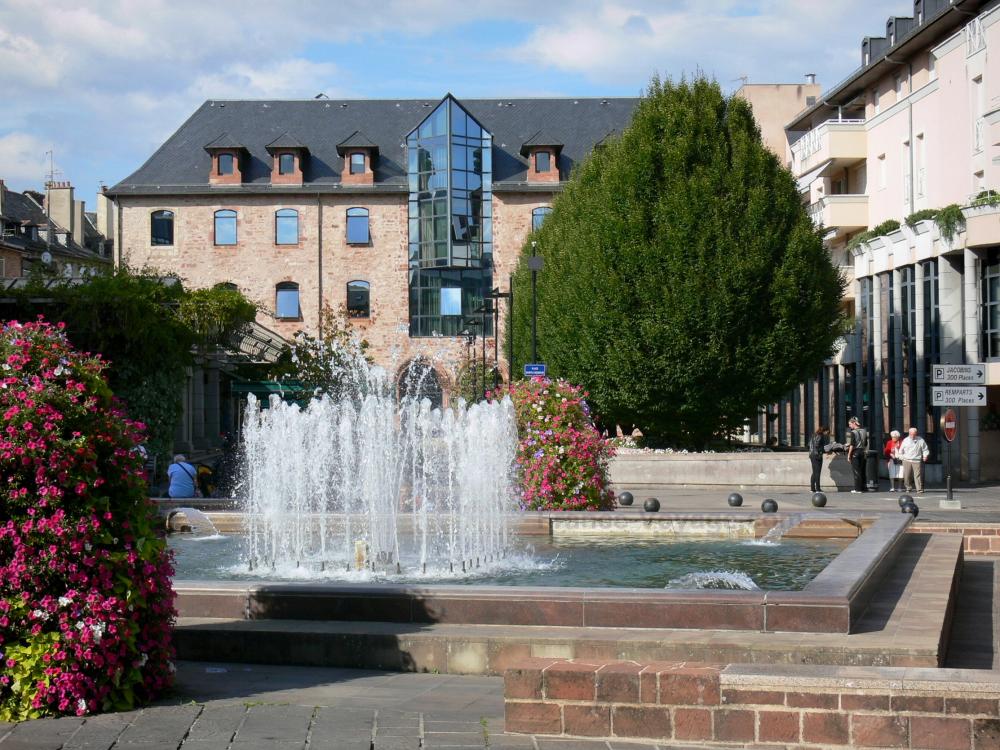 Rodez - Fountains, floral decorations and facade of the Sainte-Catherine gallery in the background
