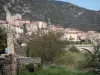 Roquebrun - Igreja e casas da aldeia, ponte, árvores e colinas, no vale do Orb, no Parque Natural Regional de Haut-Languedoc