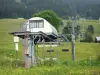 Les Rousses - Skigebied in de zomer stoeltjeslift (skilift), bloemenweiden en dennenbomen, in het Regionaal Natuurpark van de Haut-Jura