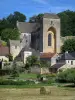 Saint-Amand-de-Coly - Église abbatiale fortifiée, maisons du village, botte de paille dans un champ et arbres, en Périgord noir