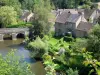 Saint-Céneri-le-Gérei - Vista da ponte sobre o rio Sarthe, as árvores ao longo da água e as casas da aldeia; no Parque Natural Regional da Normandia-Maine