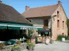 Saint-Céneri-le-Gérei - Casa de pedra e restaurante terraço decorado com vasos de flores