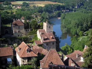 Saint-Cirq-Lapopie - Rignault museu e casas da aldeia empoleirada que domina o rio (o Lote) e as árvores à beira da água, no vale de Lote, em Quercy