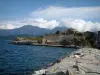 Saint-Florent - Jetée, mer, remparts de la citadelle génoise, collines et nuages en arrière-plan