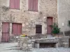 Saint-Guilhem-le-Désert - Gevel van een huis, bank en bloembakken
