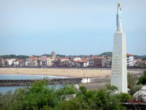 Saint-Jean-de-Luz - Estatua de la Virgen de Muskoa, Ciboure, en primer plano, con vistas a la playa y el paseo marítimo de la localidad costera de Saint-Jean-de-Luz