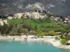 Saint-Julien-du-Verdon - Église et maisons du village surplombant le lac de Castillon aux eaux couleur émeraude, base nautique ; dans le Parc Naturel Régional du Verdon