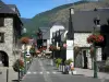 Saint-Lary-Soulan - Station thermale et de ski : rue du village bordée de maisons, de commerces et de lampadaires fleuris (fleurs) ; dans la vallée d'Aure