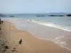 Saint-Malo - Sandy beach with fishermen, sea and rocks in the water