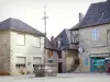 Saint-Robert - Smeedijzeren kruisen in plaats van kerk en gevels van huizen van het middeleeuwse dorp