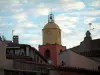 Saint-Tropez - Clocher de l'église aux couleurs vives, maisons de la vieille ville et nuages dans le ciel bleu