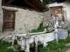 Saint-Veran - Fonte de madeira de Pierre Belle e casas da aldeia de montanha; no Parque Natural Regional de Queyras