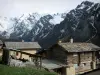 Saint-Véran - Maisons du village montagnard avec vue sur les montagnes aux cimes enneigées ; dans le Parc Naturel Régional du Queyras