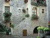 Sainte-Eulalie-d'Olt - Stenen huis ramen versierd met bloemen