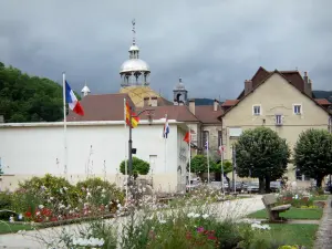 Salins-les-Bains - Cúpula e lanterna da capela de Notre-Dame-Libératrice, beco forrado com flores, árvores e casas da cidade spa