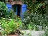 São Sulíaco - Casa com portadas azuis decoradas com flores e plantas