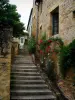 Sarlat-la-Canéda - Las escaleras y casas de piedra con fachadas decoradas con rosas trepadoras (Roses), en el Périgord