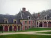 Schloß von Vaux-le-Vicomte - Nebengebäude aus Backstein und Stein, Allee gesäumt von Rasen