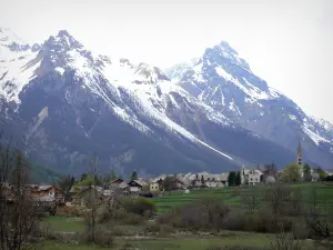 Serre-Chevalier - Serre-Chevalier 1500 (De Monetier-les-Bains), ski (ski resort): toren van de kerk van Onze-Lieve-Vrouw van de Assumptie en huizen in het dorp Monetier-les-Bains, weiden, bomen en sneeuw bedekte bergen