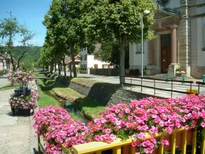 Sundgau - Igreja e casas alinhadas ao longo do rio com pequena ponte decorada com flores (aldeia de Hirtzbach)