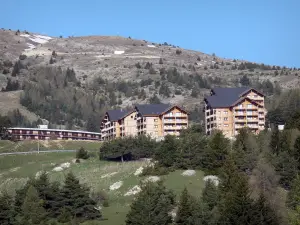 SuperDévoluy - Immeubles de la station de ski, arbres et montagne, au printemps ; dans le Dévoluy