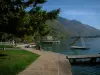 Talloires - Diapositiva Shore, el lago con pontones, las boyas y el agua, las montañas en el fondo