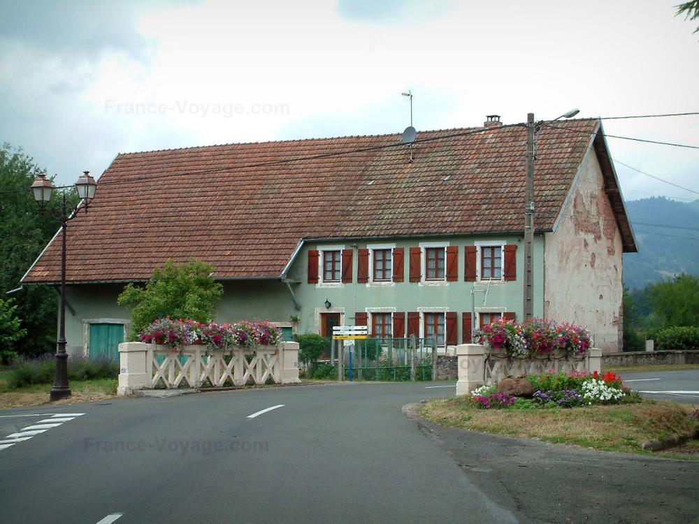 Guide du Territoire de Belfort - Villages fleuris - Route bordée de fleurs et maison en arrière-plan