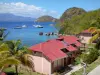 The Saintes - Casas da ilha de Terre-de-Haut com vista para o mar do Caribe e veleiros flutuando na água