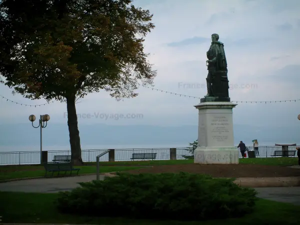 Thonon-les-Bains - Piazza del Castello con la statua del generale Dessaix, prati, arbusti, panchine e alberi, il lago di Ginevra e la banca svizzera in background