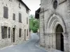 Treignac - Portal of the church Notre-Dame-des-Bans and facade of a stone house