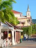 Les Trois-Îlets - Terrasse de café, maisons du bourg et clocher de l'église Notre-Dame-de-la-Bonne-Délivrance