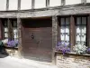 Uzerche - Oud huis met houten zijkanten met ramen versierd met bloemen