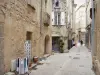 Uzès - Vieille ville : ruelle pavée bordée de boutiques et de maisons en pierre